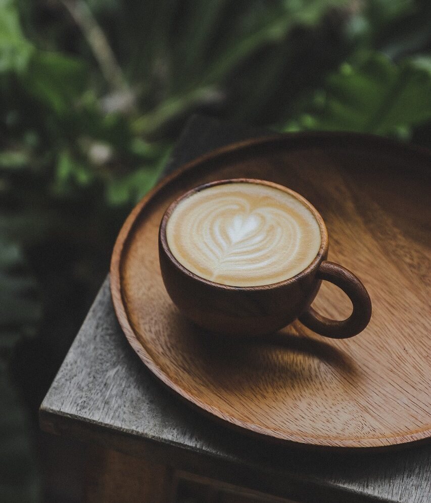 A warm cup of coffee beside an open book